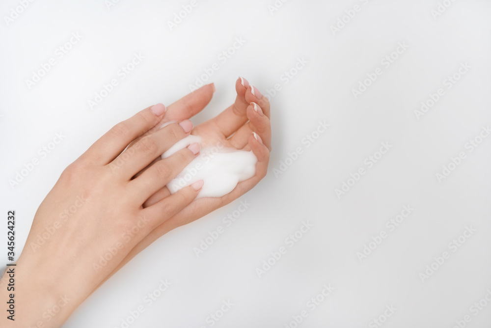 female hands apply foam on a white background female hands apply foam on a white background