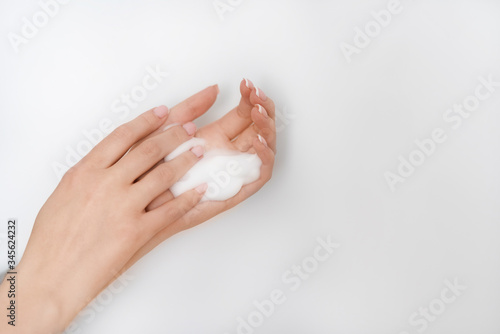 female hands apply foam on a white background