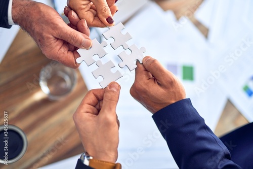 Group of business hands trying to connect puzzle pieces at office