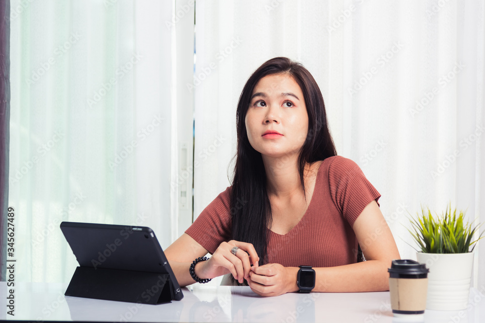 Work from home, Asian business young beautiful woman smiling sitting on desk workspace talking communicating with team video chat or conferencing on digital tablet computer at home office Work from home, Asian business young beautiful woman smiling sitting on desk workspace talking communicating with team video chat or conferencing on digital tablet computer at home office
