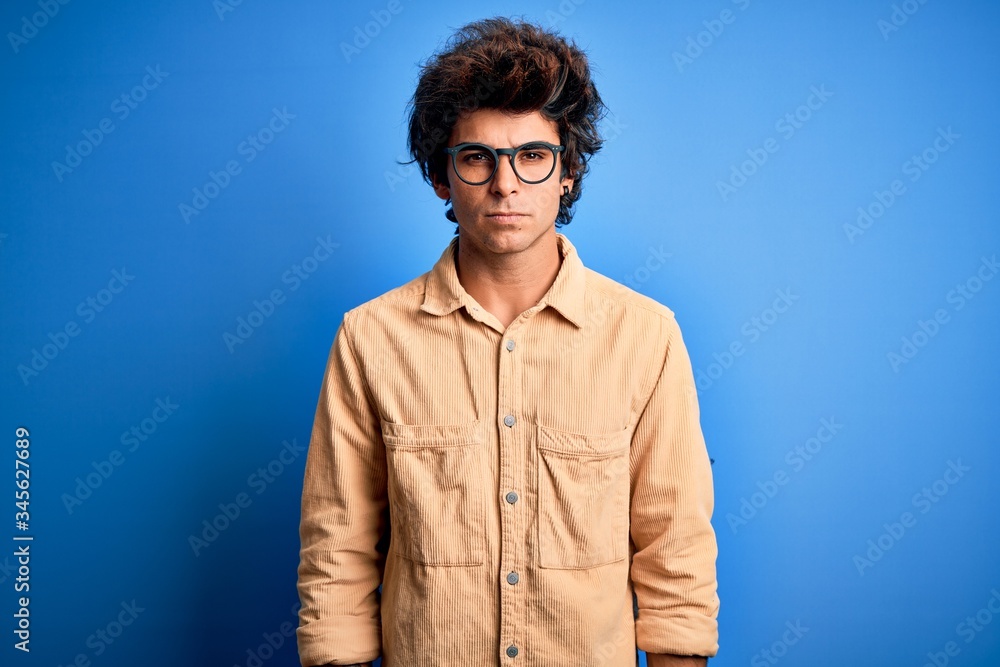 Obraz premium Young handsome man wearing casual shirt standing over isolated blue background skeptic and nervous, frowning upset because of problem. Negative person.