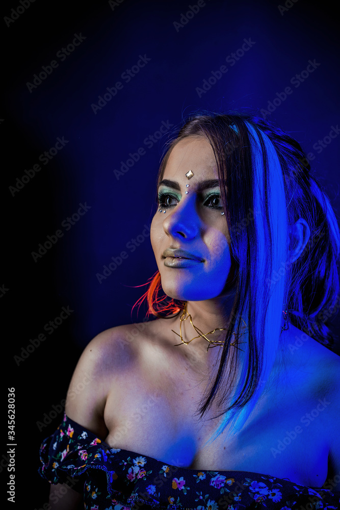 Naklejka premium ethnic girl on a black background in blue light