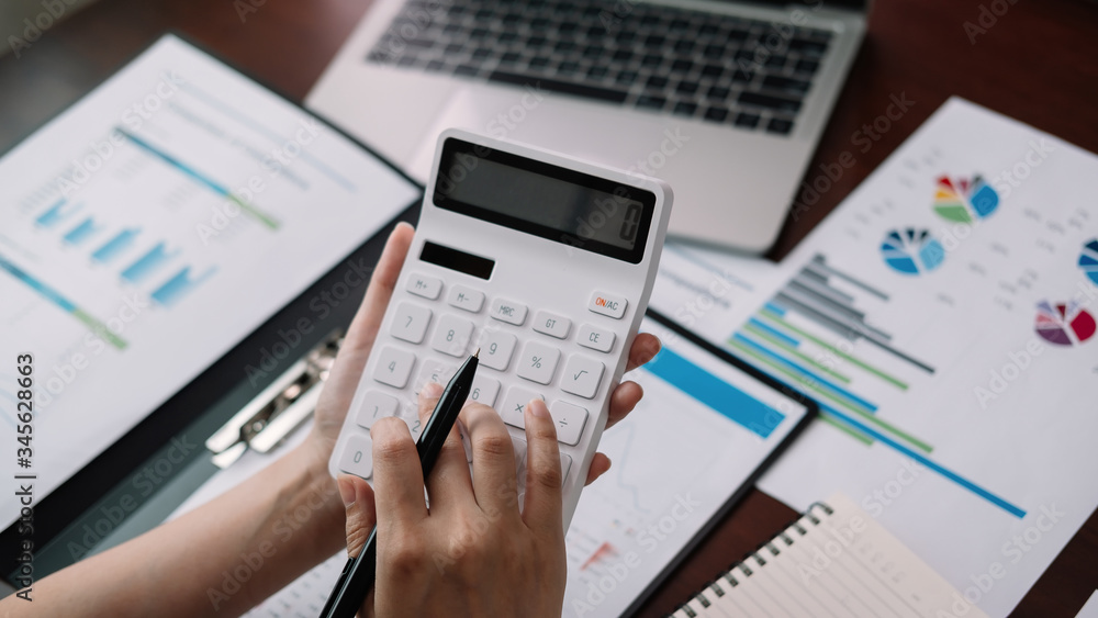 Close up Businessman using calculator and laptop for calaulating finance, tax, accounting, statistics and analytic research concept Close up Businessman using calculator and laptop for calaulating finance, tax, accounting, statistics and analytic research concept