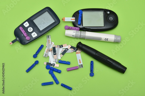 2 Diabetes set with glucometer, lancet, spare needles on green background 