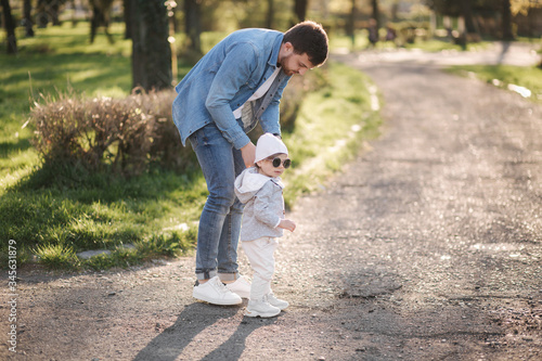 Adorable little gilr spend time with her father. Dad and daughter walk in the park. Stylish family. Happy little girl in sunglasses © Aleksandr