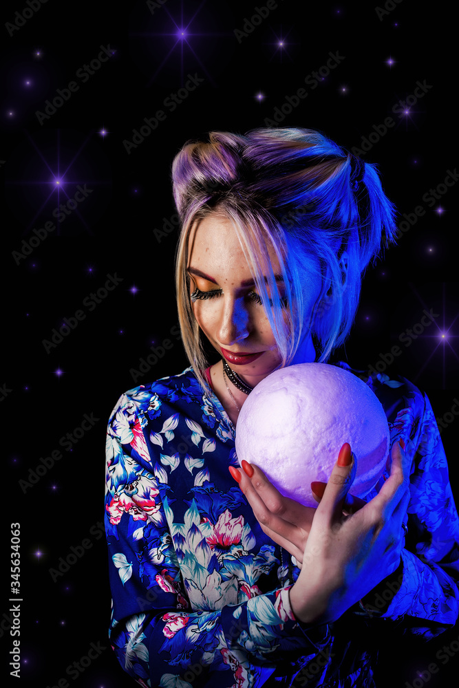 Naklejka premium Infantile girl on a black background in blue light