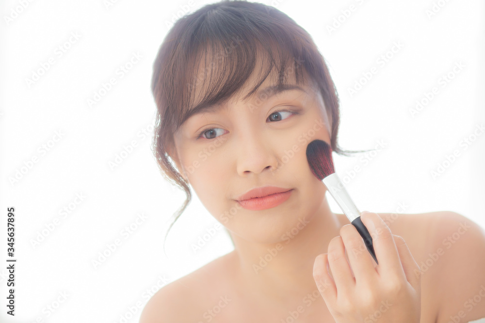 Beauty portrait young asian woman smile with face looking mirror applying makeup with brush cheek in the bedroom, beautiful of girl holding blusher, skin care and cosmetic concept. Beauty portrait young asian woman smile with face looking mirror applying makeup with brush cheek in the bedroom, beautiful of girl holding blusher, skin care and cosmetic concept.