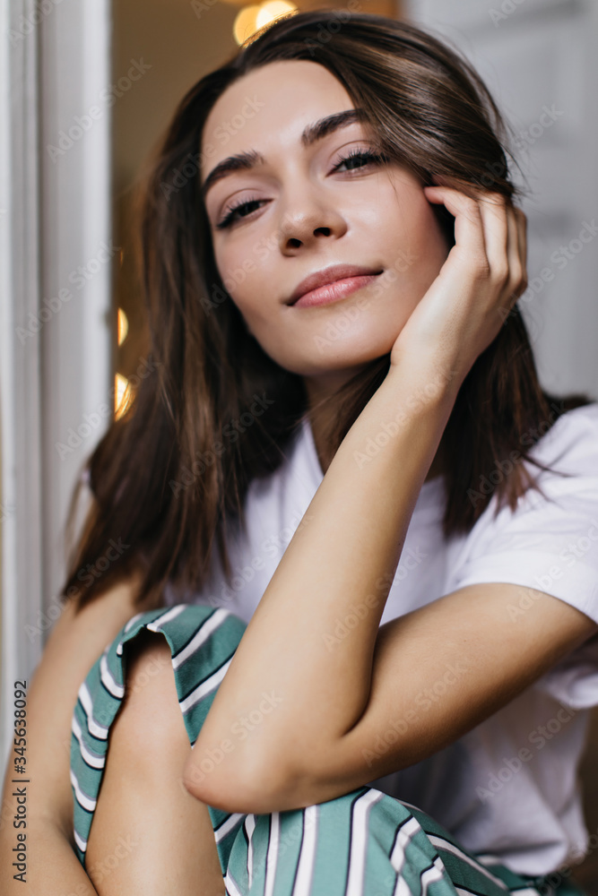 Spectacular tanned woman in pajamas posing in her apartment. Indoor photo of relaxed brunette girl with shiny hair. Spectacular tanned woman in pajamas posing in her apartment. Indoor photo of relaxed brunette girl with shiny hair.