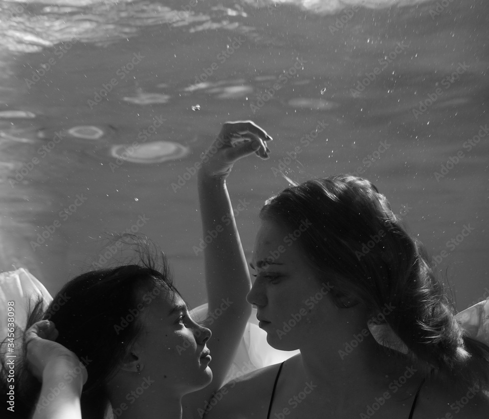 Two beautiful lesbian girls are swimming underwater. Attractiveness. Sexual poses and gestures. Female dance underwater. Swimwear and pool. Two mermaids picture picture