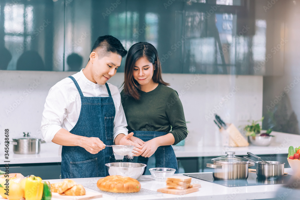 Young Adult Couple Food Cooking Together in the Kitchen at Home Young Adult Couple Food Cooking Together in the Kitchen at Home