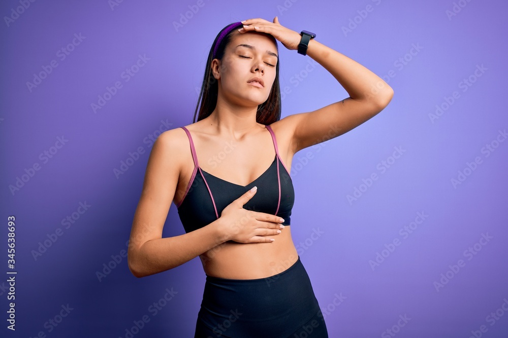 Young beautiful sporty girl doing sport wearing sportswear over isolated purple background Touching forehead for illness and fever, flu and cold, virus sick Young beautiful sporty girl doing sport wearing sportswear over isolated purple background Touching forehead for illness and fever, flu and cold, virus sick