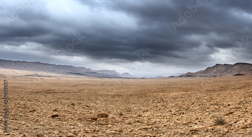 At the bottom of the deserted rocky vally under the stormy cloudy sky, multi-shot panorama.