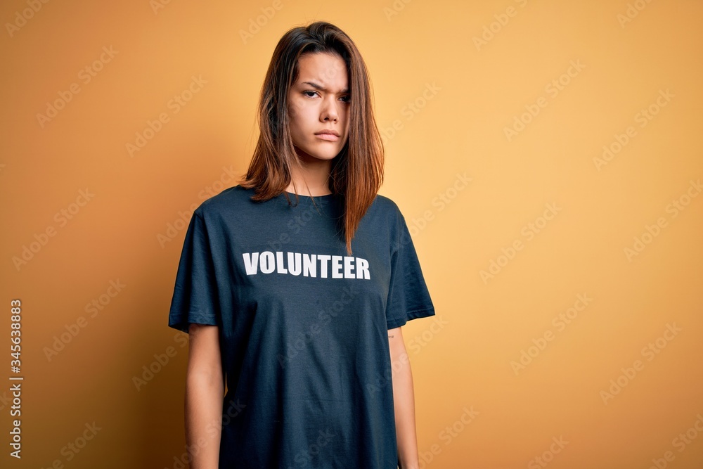Young beautiful brunette girl doing volunteering wearing t-shirt with volunteer message word skeptic and nervous, frowning upset because of problem. Negative person. Young beautiful brunette girl doing volunteering wearing t-shirt with volunteer message word skeptic and nervous, frowning upset because of problem. Negative person.