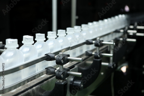 Fototapeta Naklejka Na Ścianę i Meble -  pharmaceutical industry, medicine pills are filling in the plastic bottle on production line machine conveyor at the medical factory. Ampoule filling and sealing machine, equipment in pharmaceutical.