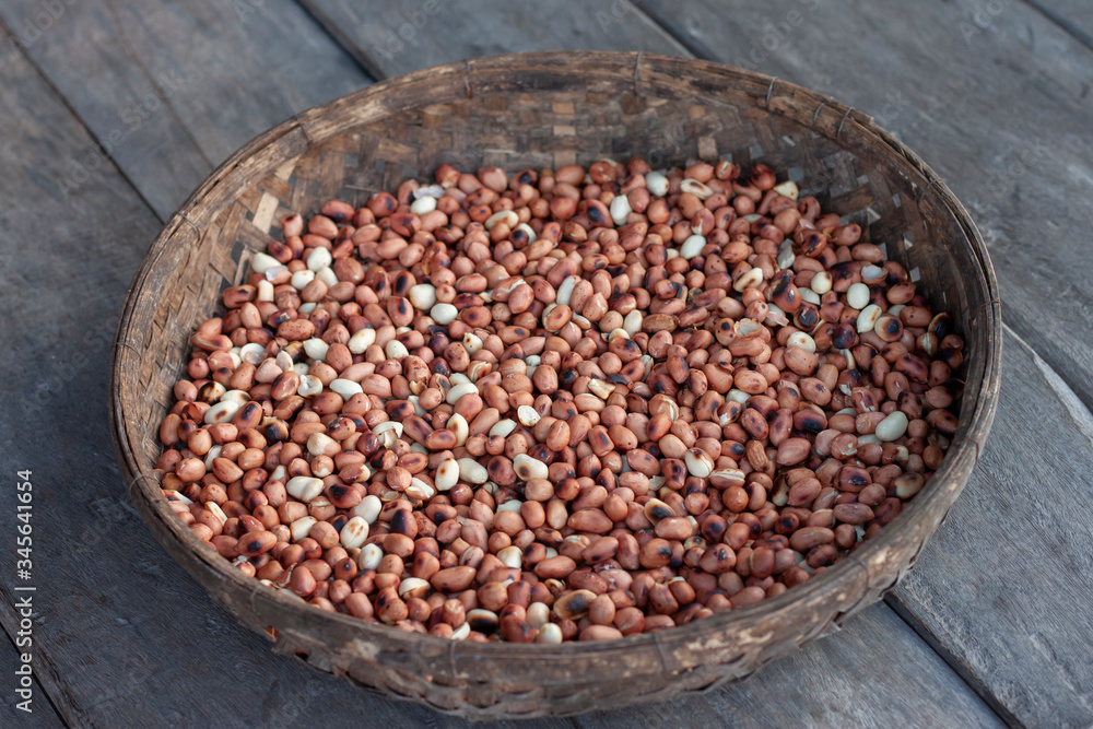 Roasted peanuts in bamboo weaving basket on wooden table background. Roasted peanuts in bamboo weaving basket on wooden table background.