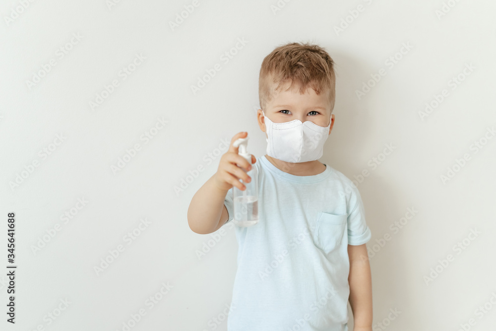 Boy in Medical Face Mask Hold Sanitiser Bottle. Caucasian Child Wearing Flu Protection Looking at Camera. Toddler Showing Antiseptic, Sterilization Gel. Corona Virus Pandemic Concept Boy in Medical Face Mask Hold Sanitiser Bottle. Caucasian Child Wearing Flu Protection Looking at Camera. Toddler Showing Antiseptic, Sterilization Gel. Corona Virus Pandemic Concept