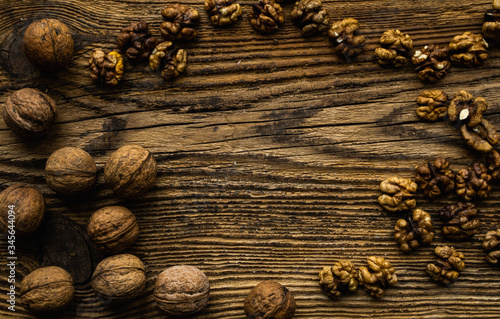 Walnut scattered on the wooden vintage table. Walnuts is a healthy vegetarian protein nutritious food. Walnut on rustic old wood.