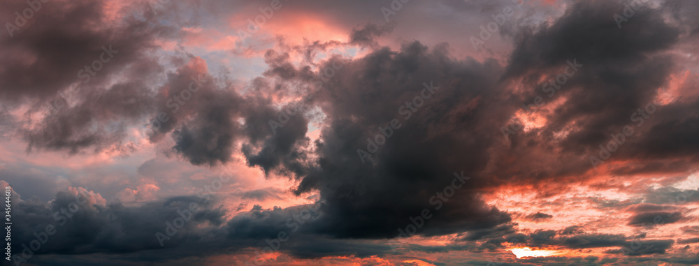 sunset panorama with raspberry clouds over a small town against a blue sky