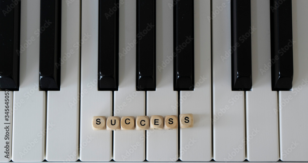 Naklejka premium A word success lies on the piano keyboard