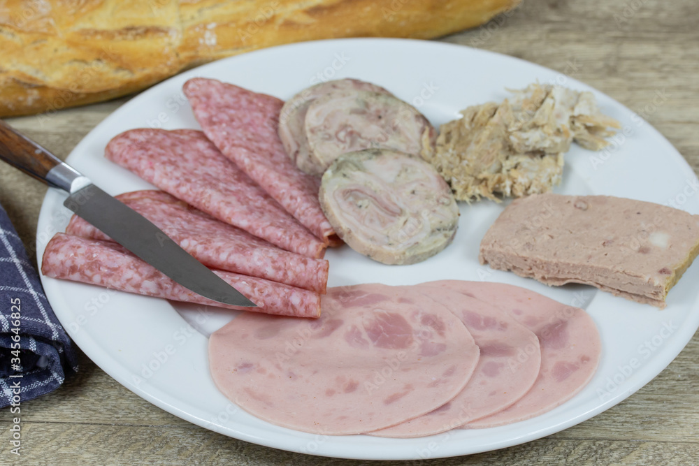 assiette de charcuterie et baguette de pain sur une table