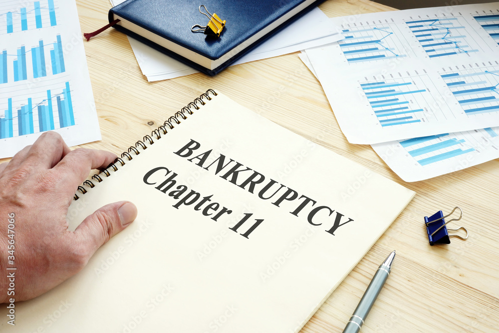 Businessman reads Bankruptcy Chapter 11 book. фотография Stock | Adobe Stock