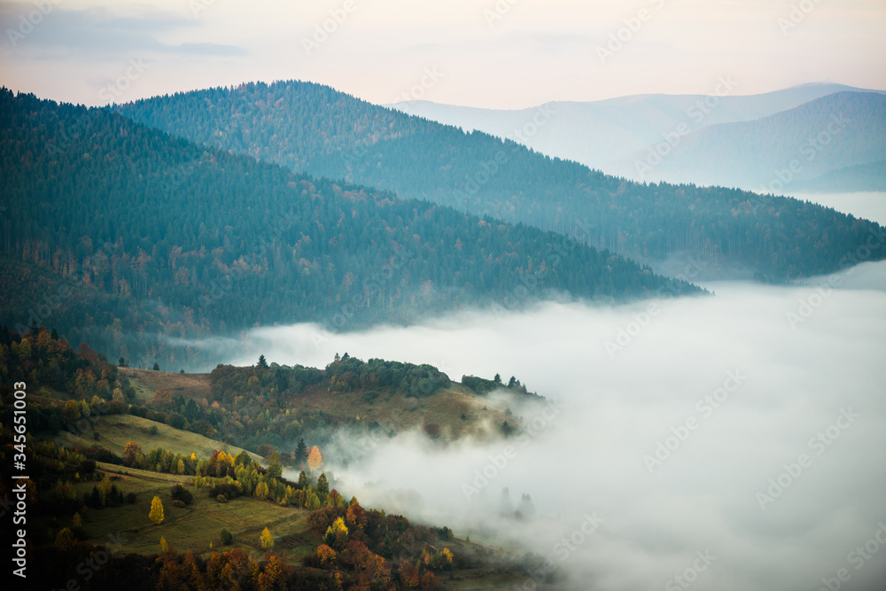 Beautiful morning landscape with autumn foggy mountains.