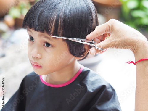 Cute little girl getting hair cut