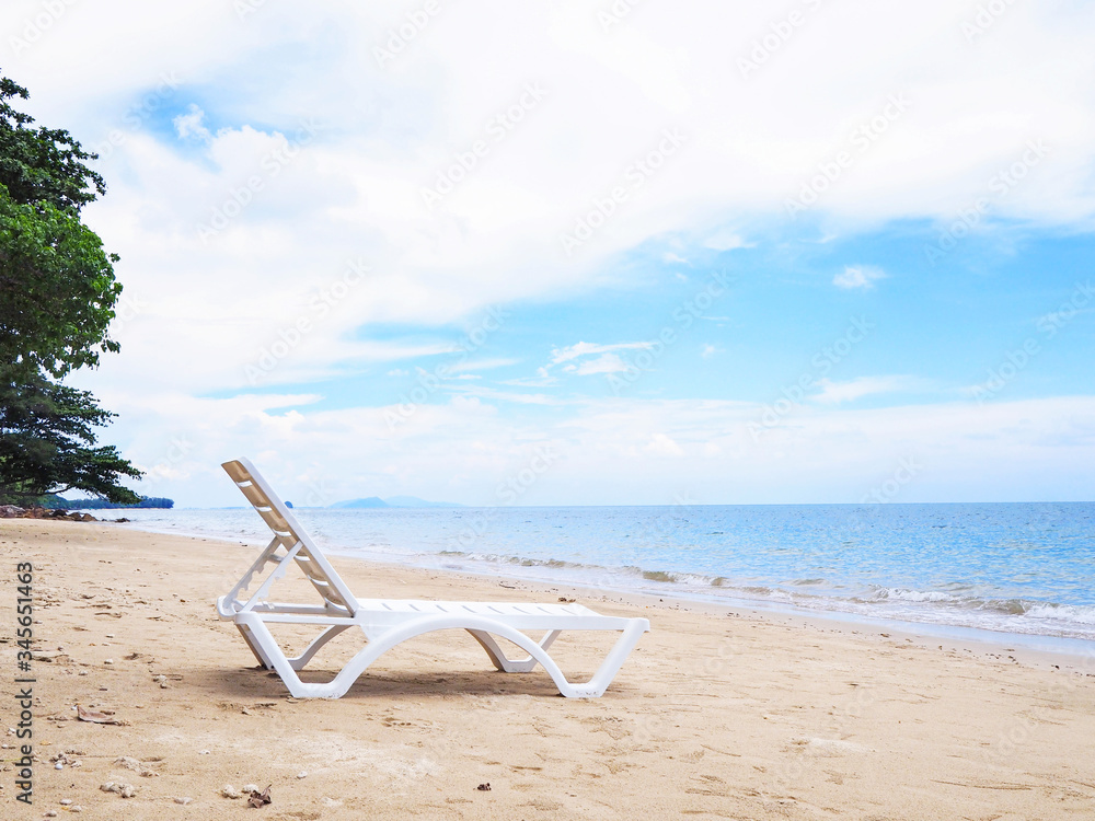 white sun bed on sandy beach against blue sky. white sun bed on sandy beach against blue sky.