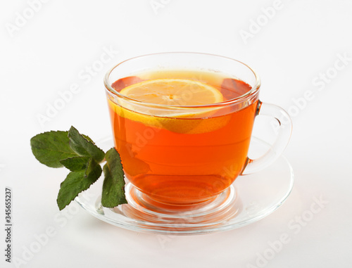 glass mug of tea with mint leaves and lemon, white background, isolate