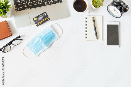 Flat lay of work from home, workspace with laptop and smartphone, credit card shopping online concept to prevent epidemic