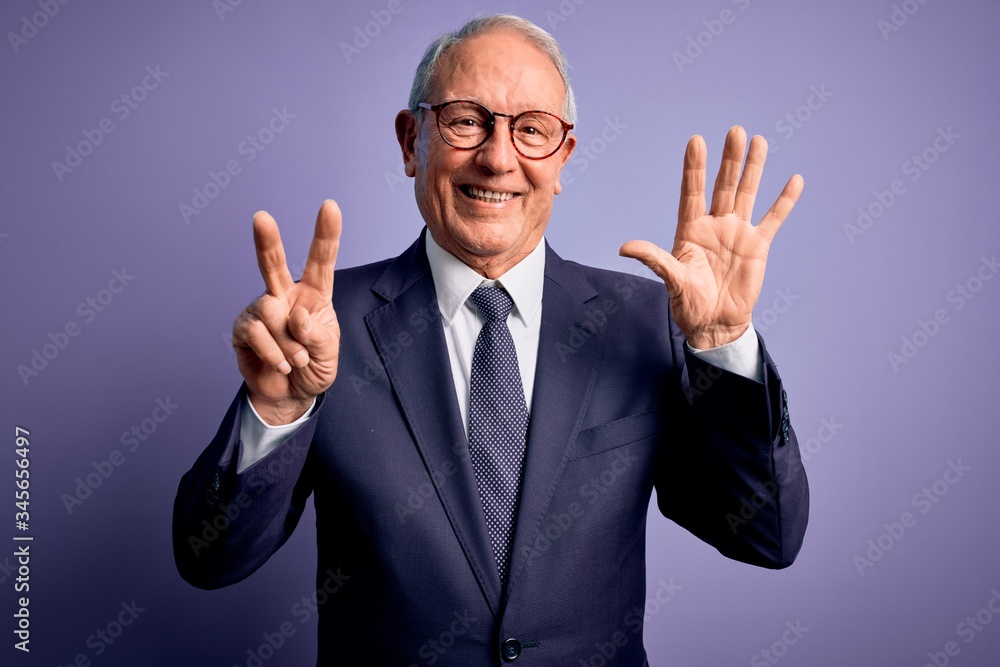 Grey haired senior business man wearing glasses and elegant suit and tie over purple background showing and pointing up with fingers number seven while smiling confident and happy. Grey haired senior business man wearing glasses and elegant suit and tie over purple background showing and pointing up with fingers number seven while smiling confident and happy.