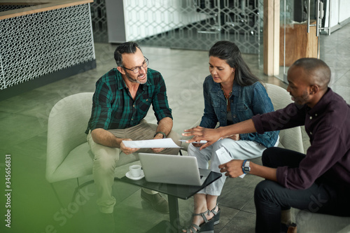 Casual meeting of diverse business team analyzing financial data
