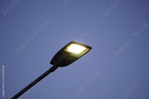 Lighting mast with a lantern on a city street during the day. Lighting of roads and streets, stadiums against the blue sky.