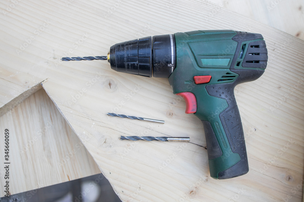 Close up Electric drill, Drill set, Screwdriver set, adapter on wooden table background and copy space. Hammer drill or screwdriver, Electric cordless hand drill on wooden. maintenance home concept. Close up Electric drill, Drill set, Screwdriver set, adapter on wooden table background and copy space. Hammer drill or screwdriver, Electric cordless hand drill on wooden. maintenance home concept.