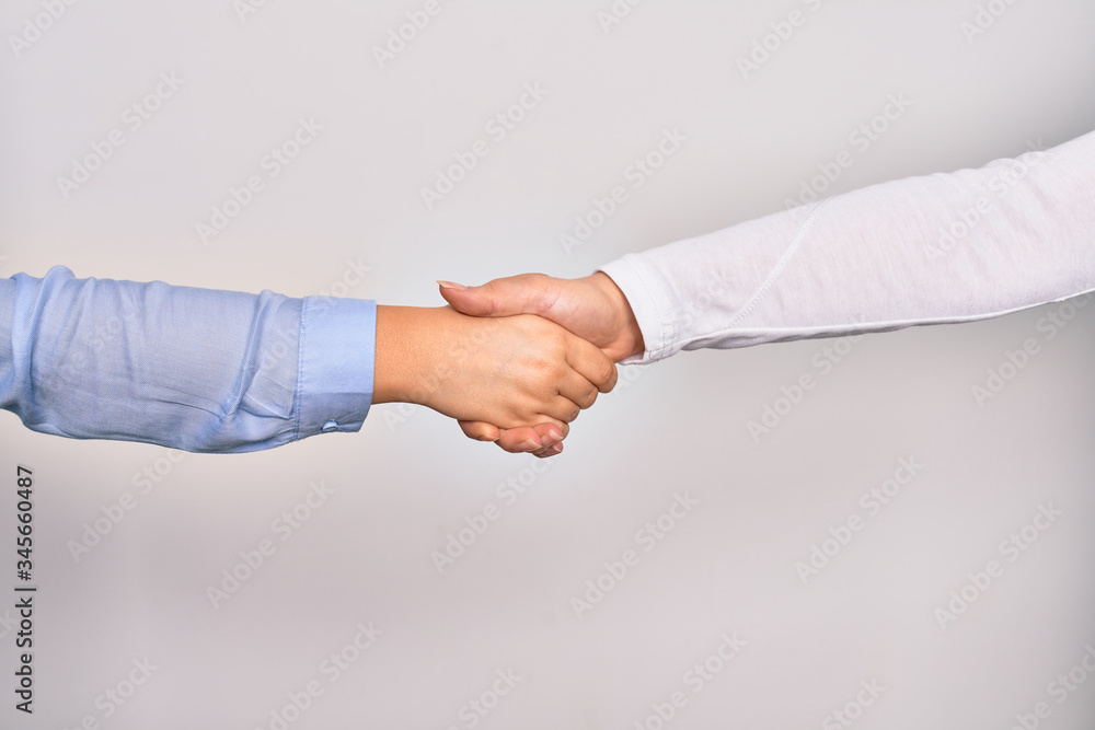 Handshake of two hands of young caucasian businesswomen for agreement over isolated white background Handshake of two hands of young caucasian businesswomen for agreement over isolated white background