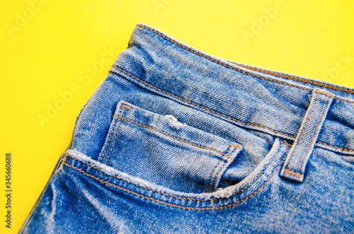 Jeans on a yellow background. Jeans elements, pockets, seams in close-up. Ripped jeans. Copy Space