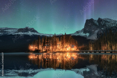 Wooden lodge illuminated with Aurora borealis on Emerald lake at Yoho national park photo