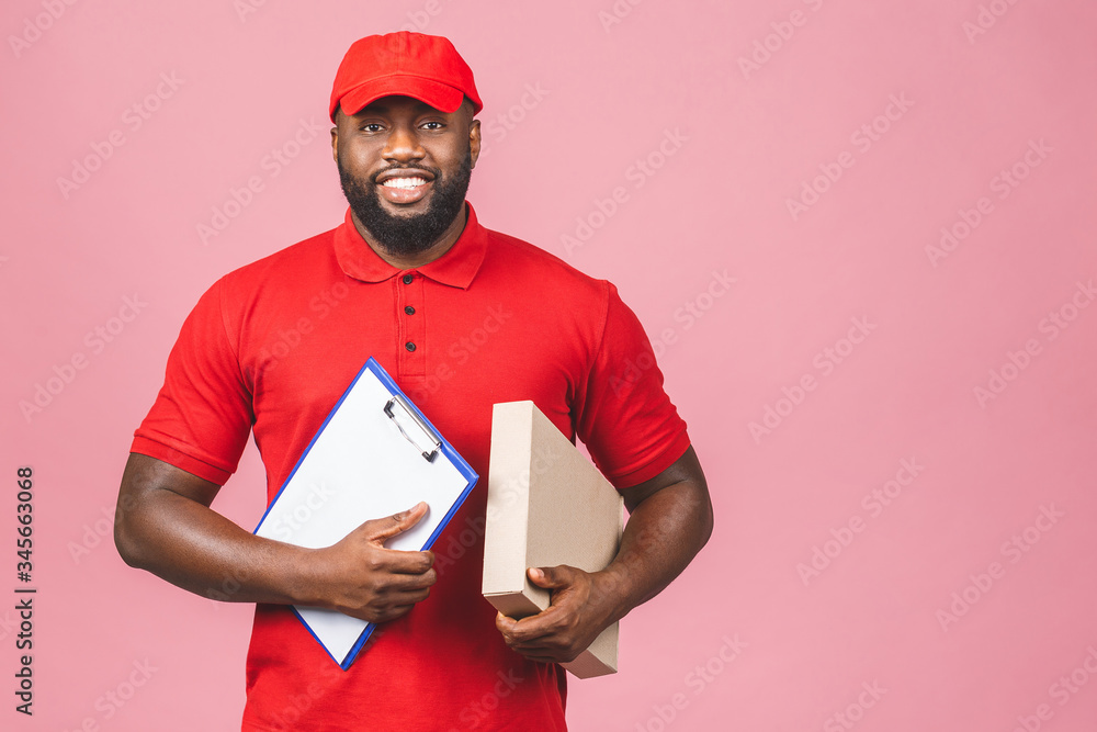 Delivery concept. African american delivery man carrying parcel and presenting receiving form isolated over pink background. Delivery concept. African american delivery man carrying parcel and presenting receiving form isolated over pink background.