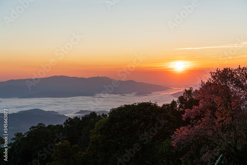 Beautiful sunrise and colorful sky in the mist over the mountain