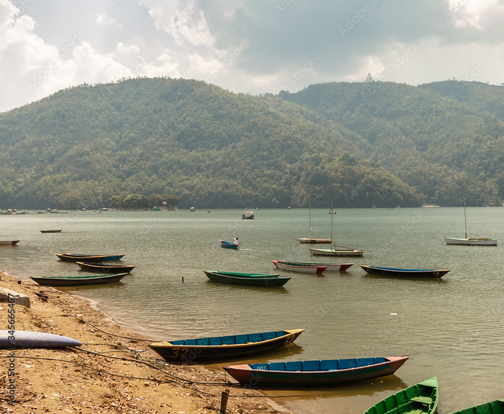 Wooden boats idle on the banks of the Phewa lake in the Himalayan city of Pokhara
