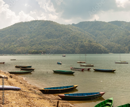 Wooden boats idle on the banks of the Phewa lake in the Himalayan city of Pokhara 