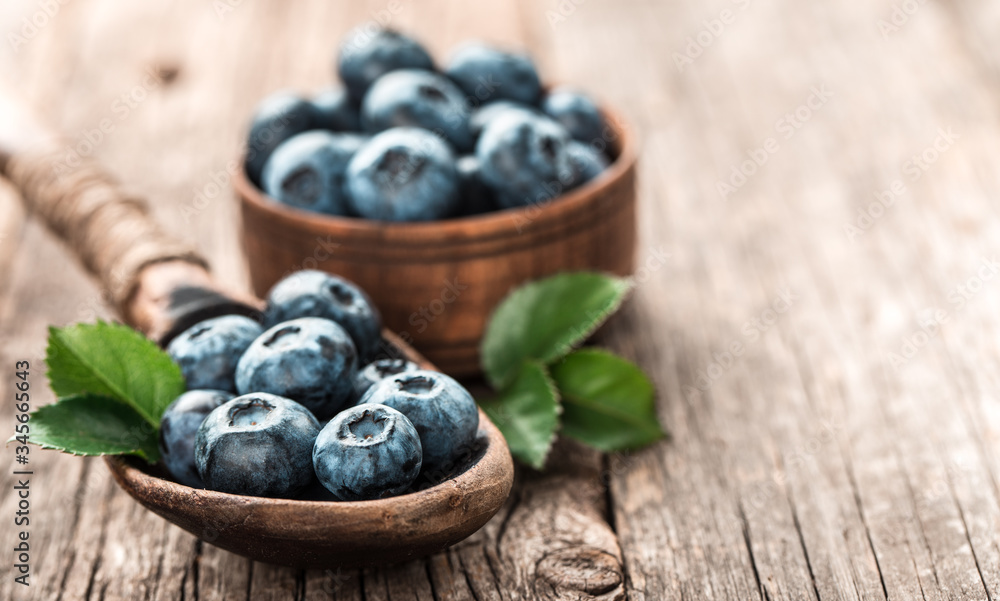 Blueberries in wooden spoon on old wood table. Healthy eating and nutrition concept. Blueberries in wooden spoon on old wood table. Healthy eating and nutrition concept.