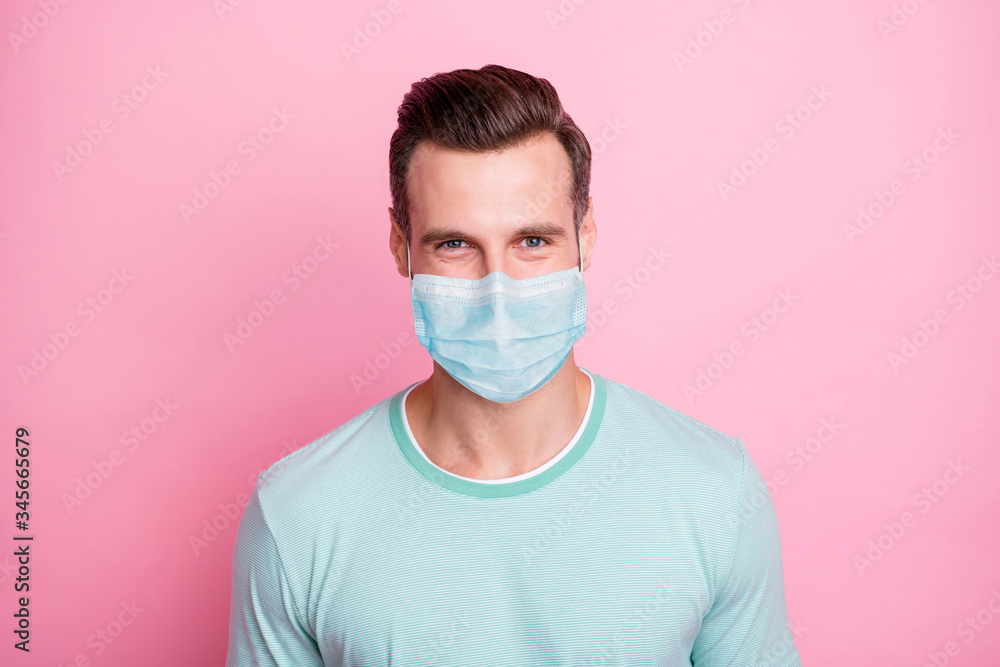 Close up photo of cheerful glad man look keep self-isolation social distance stop spread covid-19 infection wear white fabric mask isolated over pink color background Close up photo of cheerful glad man look keep self-isolation social distance stop spread covid-19 infection wear white fabric mask isolated over pink color background