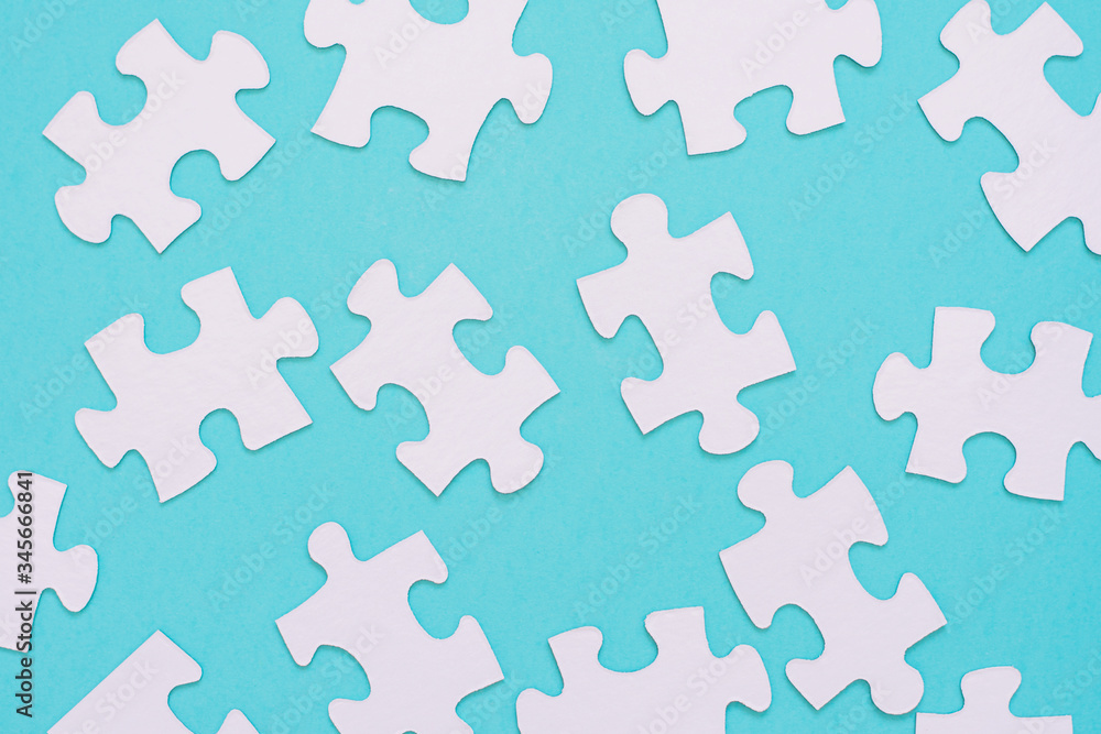 White puzzle pieces scattered on a blue background White puzzle pieces scattered on a blue background