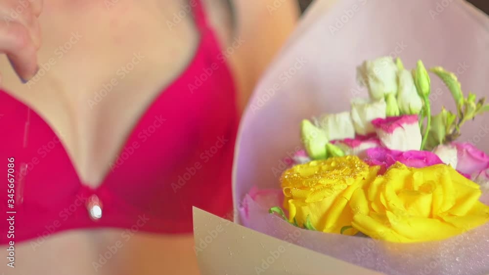 a bouquet of flowers roses of different colors and varieties is sprayed and watered by a girl in a bra a bouquet of flowers roses of different colors and varieties is sprayed and watered by a girl in a bra