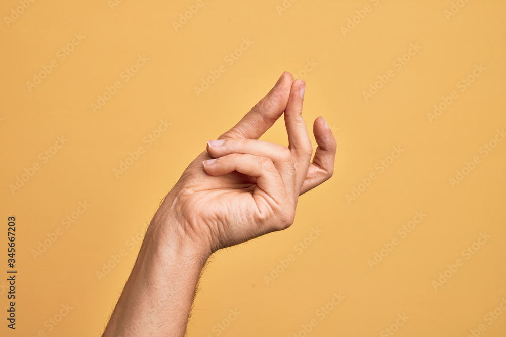Hand of caucasian young man showing fingers over isolated yellow background snapping fingers for success, easy and click symbol gesture with hand - obrazy, fototapety, plakaty 