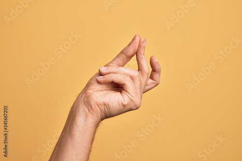 Leinwand Poster Hand of caucasian young man showing fingers over isolated yellow background snap