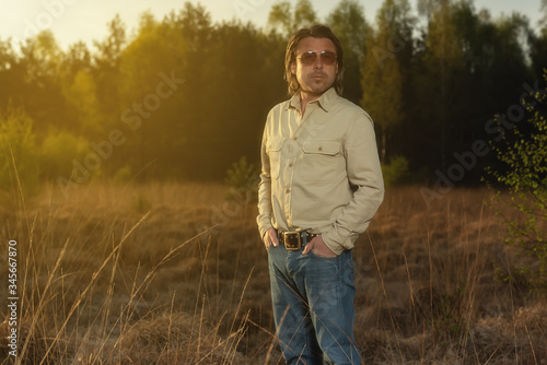 Man in shirt and sunglasses in nature at sunrise during spring. © ysbrandcosijn