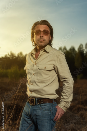 Man in shirt and sunglasses in nature reserve at sunrise during spring. © ysbrandcosijn