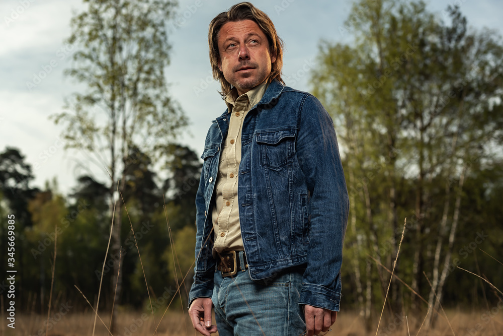 Man in denim jacket in nature reserve at sunrise during spring. Man in denim jacket in nature reserve at sunrise during spring.